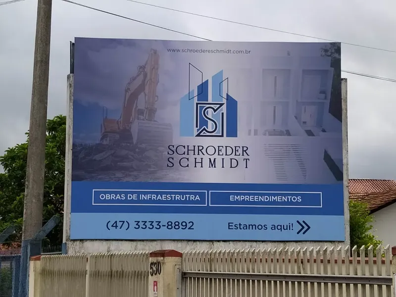Placa de obra da Schroeder Schmidt instalada na calçada, com dados do empreendimento