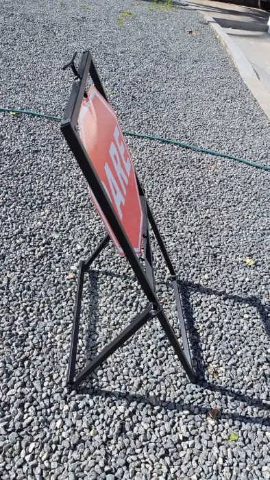 Placa de sinalização viária "Pare", vista de trás do cavalete